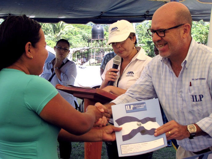 Jecenia Hernández Rivas recibe de manos del Director Ejecutivo del ILP, Ing. David Henríquez su título de propiedad.