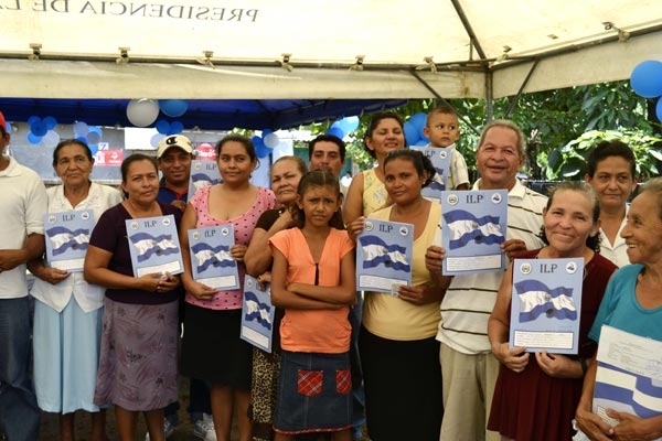 Familias del Proyecto Las Mercedes, en el municipio de Zacatecoluca muestran sus escrituras de propiedad.