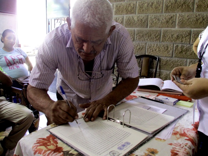 Familias de la comunidad “Las Margaritas”, firman su escritura de propiedad, que los acredita como legítimos propietarios del lote en el que habita.