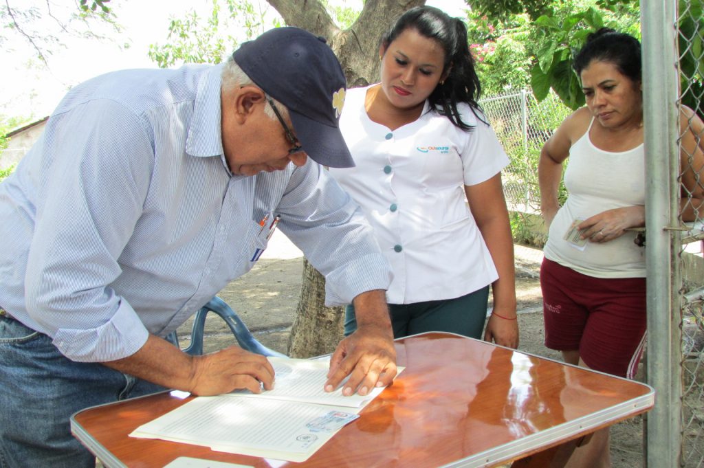 Ing. Carlos Bermúdez, de la Unidad de Promoción, explica a las familias de la comunidad de línea férrea Huiscoyol, el procedimiento para iniciar el acto de firma de escrituras.